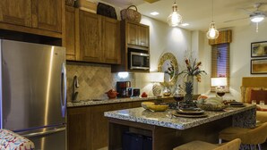 Una cocina moderna con armarios de madera, electrodomésticos de acero inoxidable y encimera de granito.