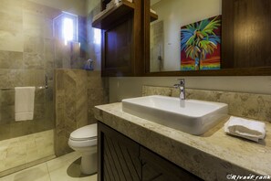 A modern bathroom with a marble sink, a toilet, and a glass shower enclosure. - V177 Condo at Vallarta Romantic Zone (Puerto Vallarta)