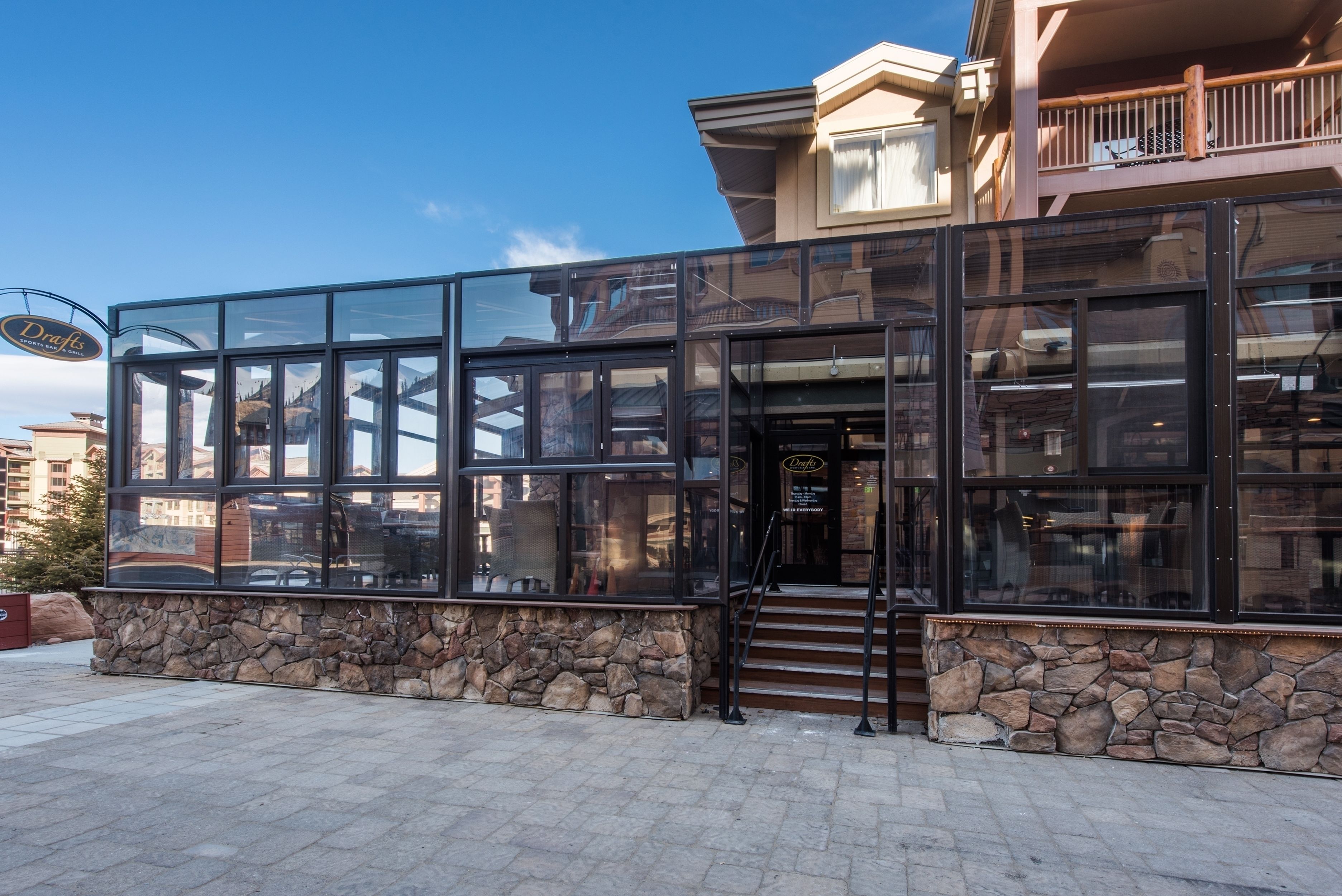 A modern building with large glass windows and a stone facade.