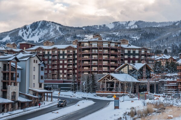 Ein mehrstöckiges Hotel mit Innenhof, umgeben von schneebedeckten Bergen.