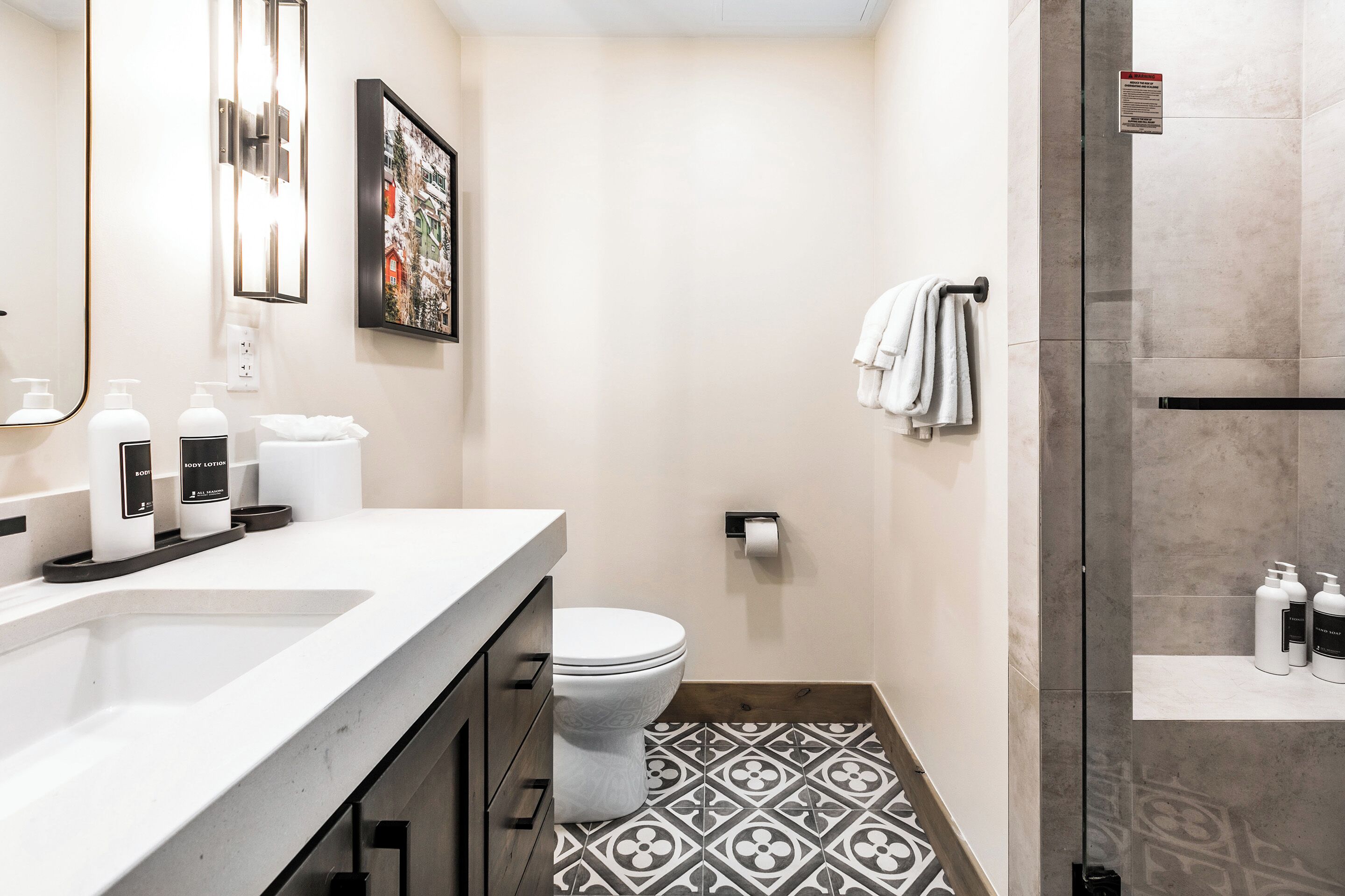 Une salle de bain moderne avec un lavabo blanc, des toilettes et un espace douche.