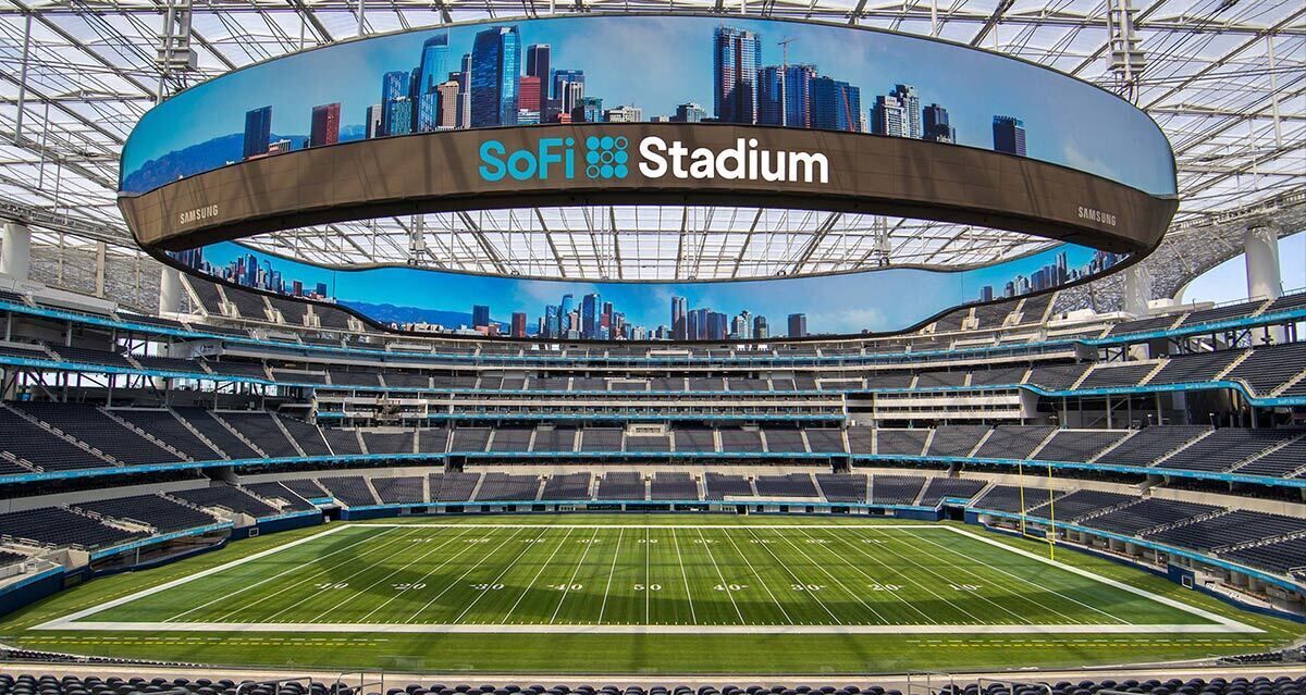 Un estadio con una gran pantalla digital que muestra un horizonte urbano y el texto 