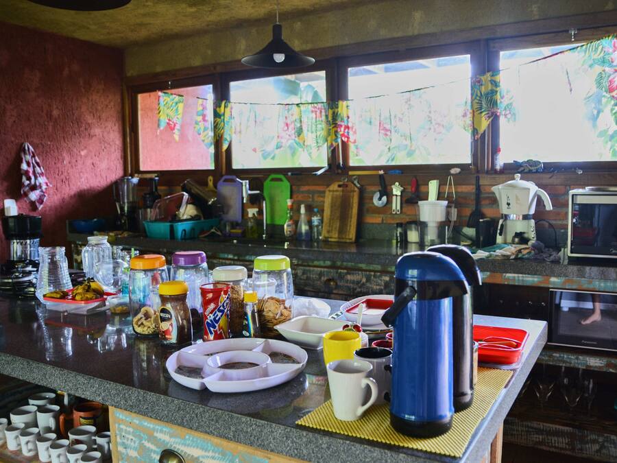 Una cocina con encimera de granito, diversos electrodomésticos y una ventana con vistas a la vegetación.