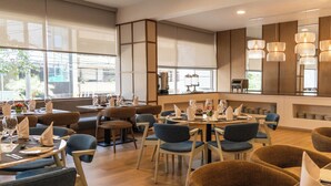 Un restaurant moderne avec des tables rondes, des chaises bleues et un plancher en bois.