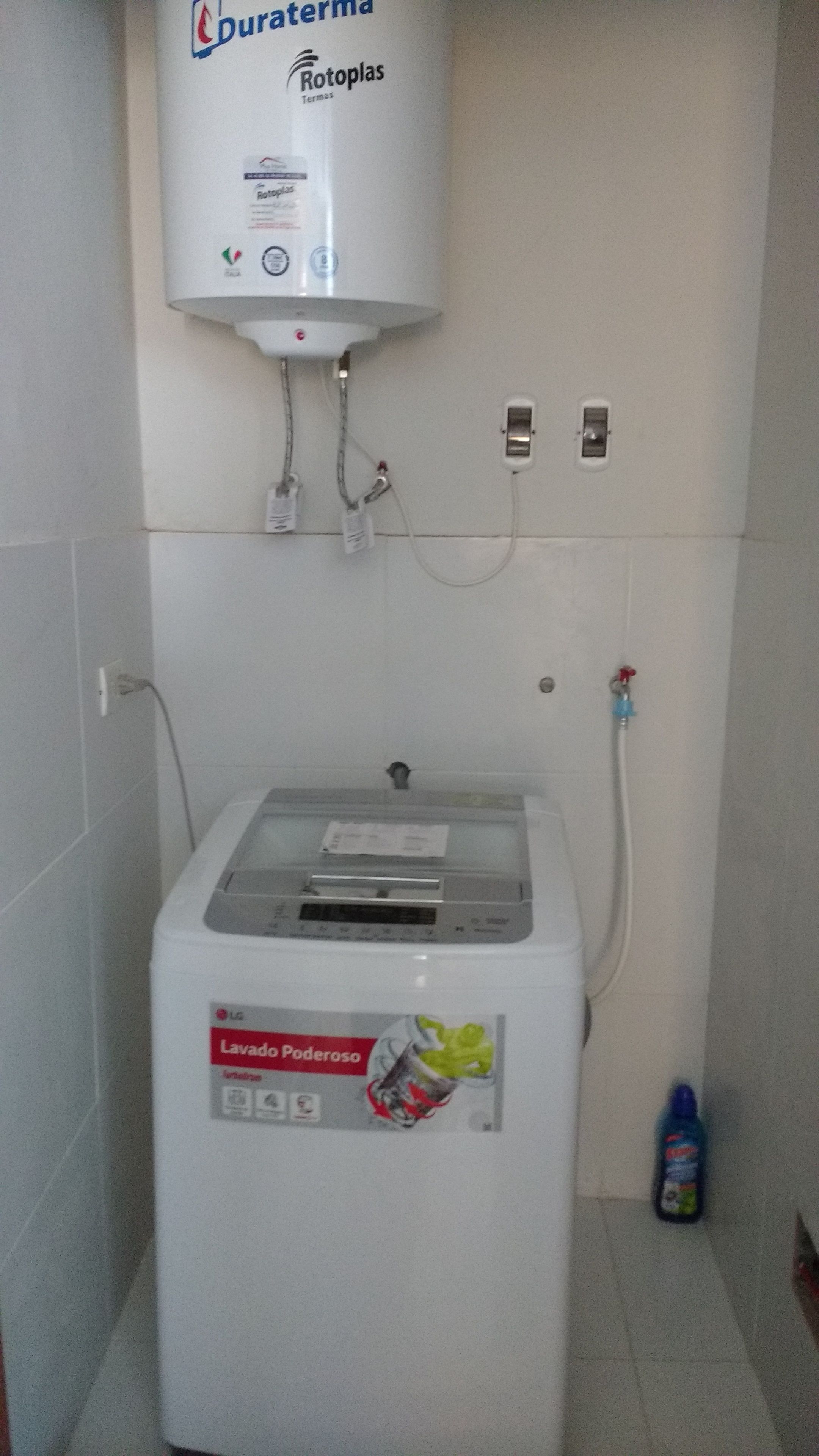 A water heater with a control panel, a power outlet, and a water filter bottle on the floor.