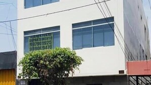 A building with multiple windows and a parked car in front. - Lima Flats 1 (Lima)
