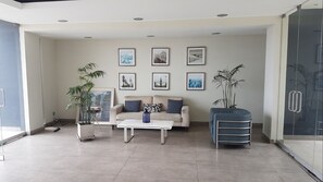 A modern living room with a sofa, coffee table, and framed pictures on the wall.