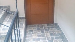 A wooden door with the number 202, a metal handrail, and a tiled floor. - Lima Flats 4 (Lima)
