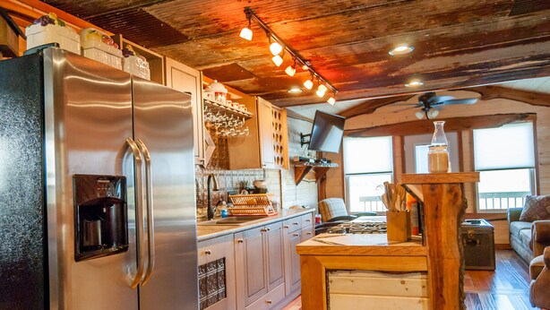 A modern kitchen with stainless steel appliances, wooden cabinets, and a wooden island. - Rustic Cabin - Jetted Tubs - Wi-Fi - Wonderful Views - Grill - Firepit - Porch (Makanda)