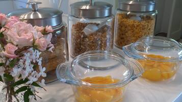 A buffet table with various food items and a vase of flowers.