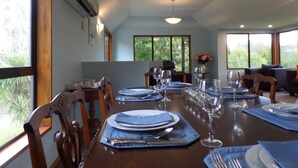 A dining area with a long table set for six, surrounded by chairs.