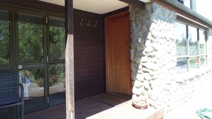 A wooden door with a stone wall, a glass door, and a wooden bench.