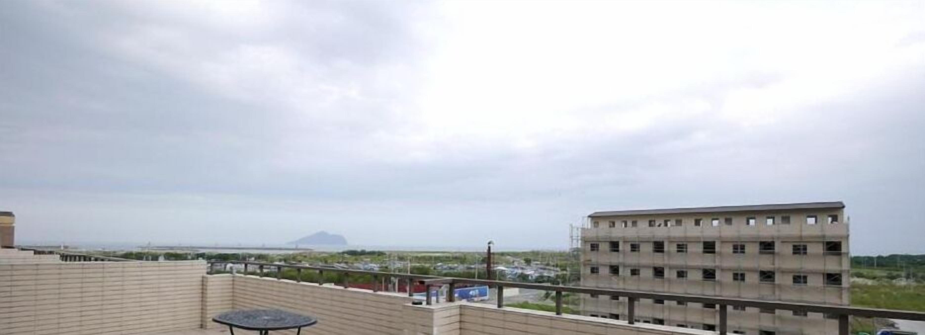 Terrassa al terrat amb vistes a una muntanya allunyada i un edifici en construcció.