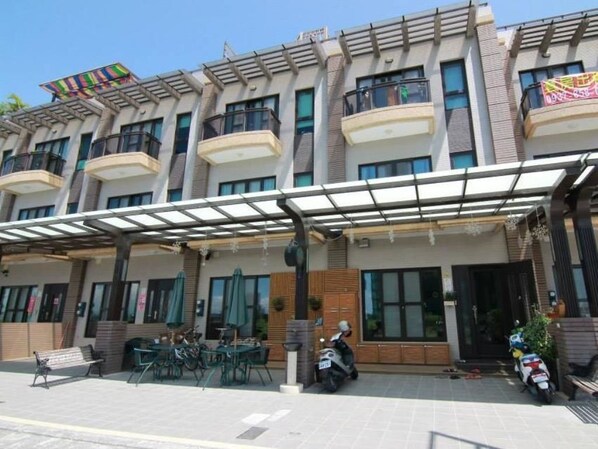 A multi-story hotel with outdoor seating and a covered entrance. - Lambo Stay (Toucheng)