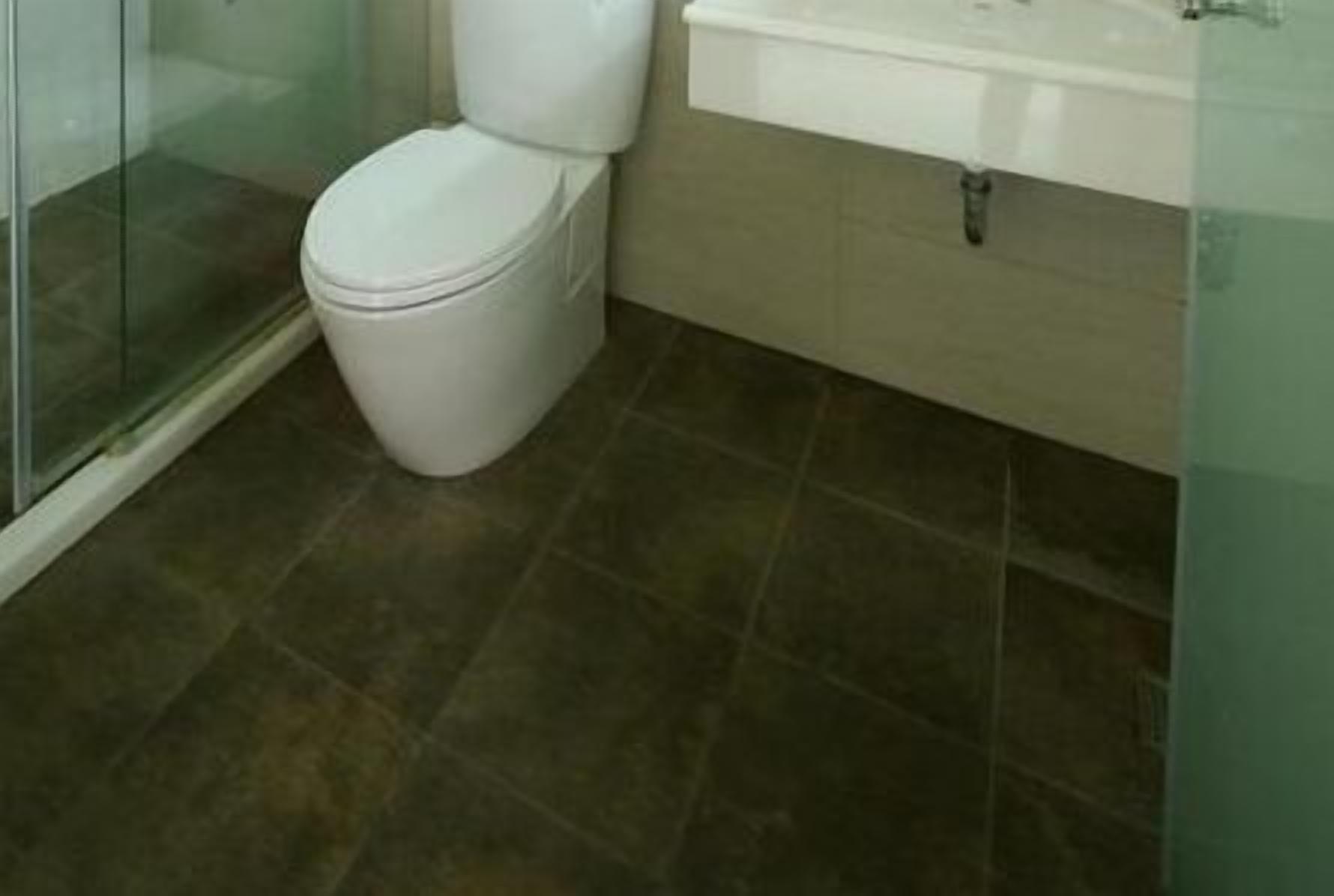 A bathroom with a toilet, a sink, and a glass shower enclosure.