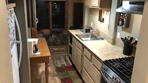 Una cocina compacta con fregadero, estufa y comedor.