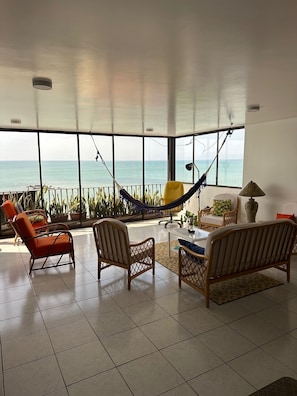 Relax in comfort with a hammock, sofa, and armchair, taking in the stunning sea view from the large window.