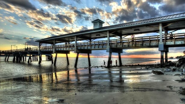 A pier extending over a body of water with a sunset in the background. - Cute Cottage 3 Blocks to Beach & Village! BRAND NEW remodel Fall of 2024! (Saint Simons Island)