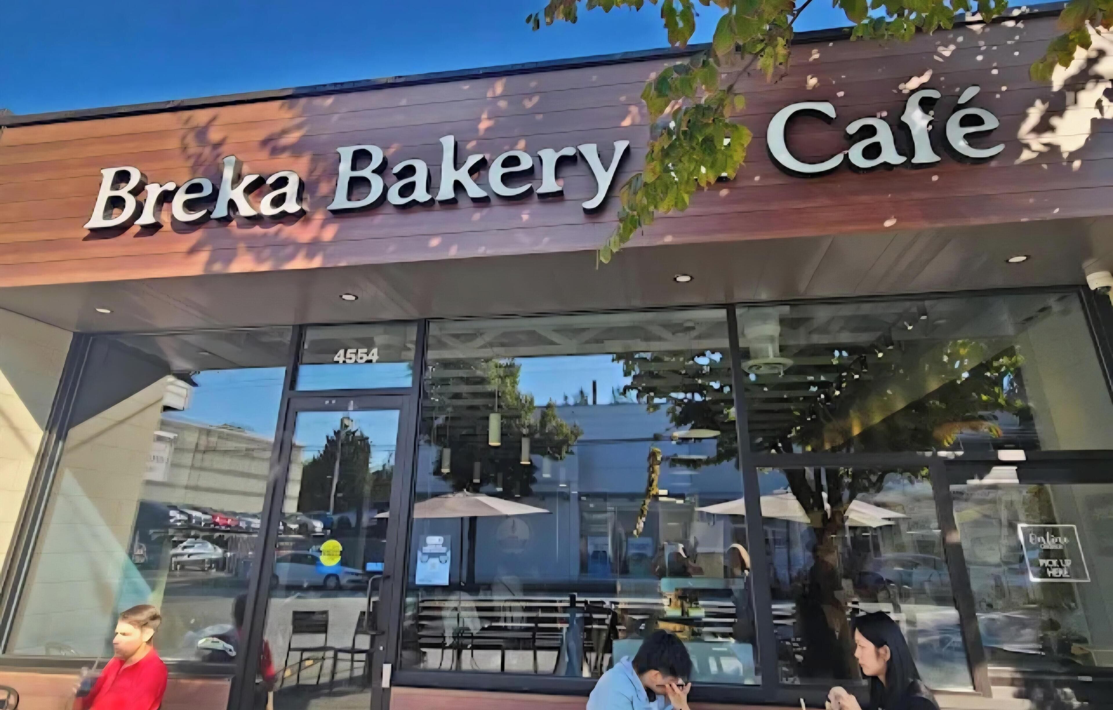 Breka Bakery Café with a glass storefront, outdoor seating, and a visible address number.