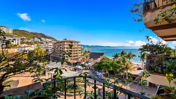 A coastal cityscape with a beach, buildings, and a clear sky.
