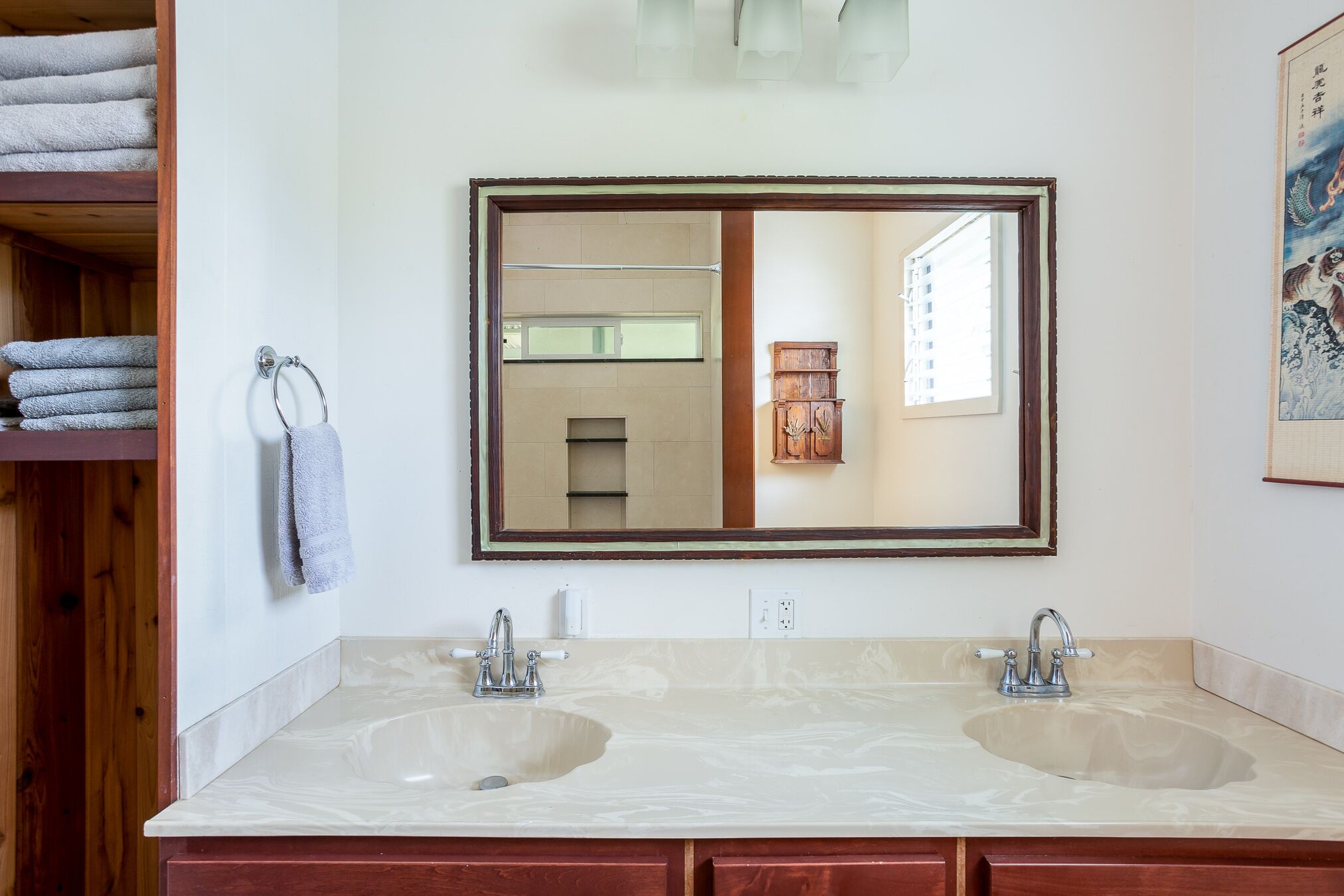 A bathroom with two sinks, a large mirror, and a towel rack.