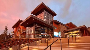 A modern hotel with a multi-level structure, large windows, and a staircase leading to the entrance.