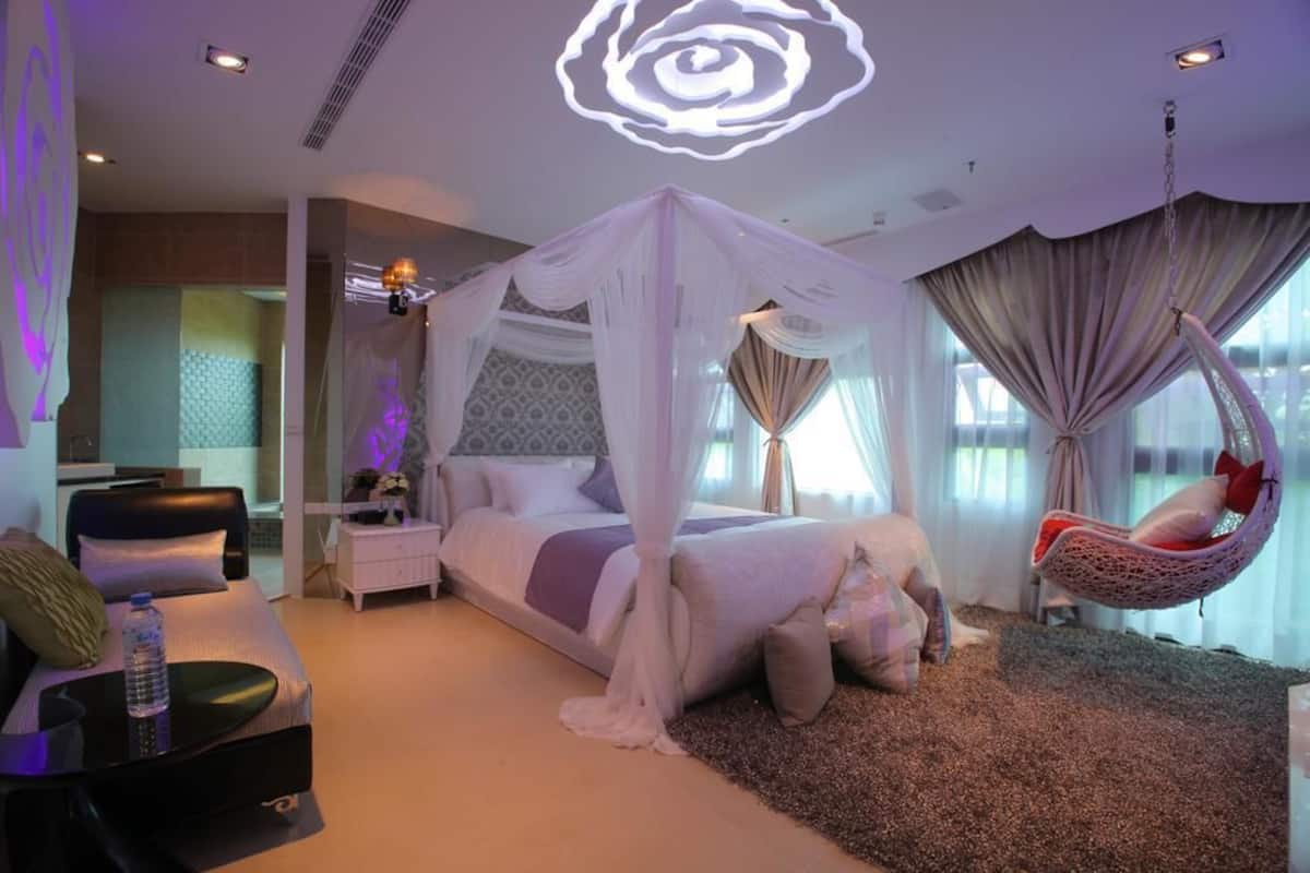 Quarto com cama de dossel, cadeira suspensa e cortina.