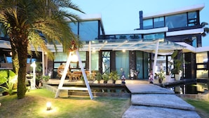 A modern house with a glass conservatory, a pool, and outdoor furniture. - Maple House Riverside (Dongshan)