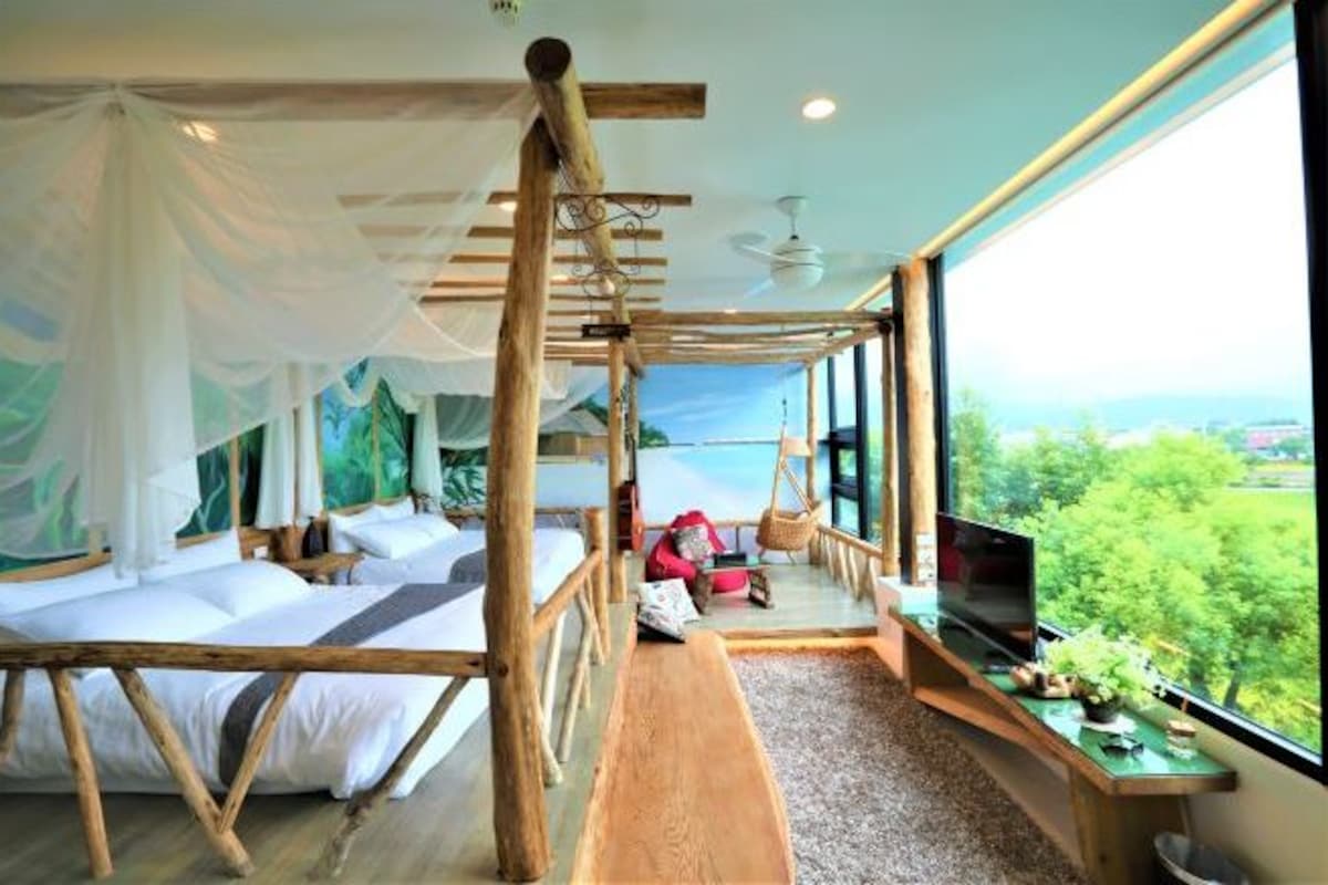 A room with a bed, a TV, and a view of the outdoors.