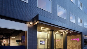 A modern building with a bar lounge, large glass windows, and a neon sign. - Moxy Tokyo Kinshicho (Tokyo)