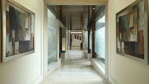 Un passadís amb parets de vidre, obres d'art i un sòl polit.