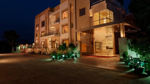 A multi-story hotel with a modern design, featuring balconies and large windows.