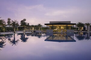 Una piscina al aire libre, sillones reclinables de piscina