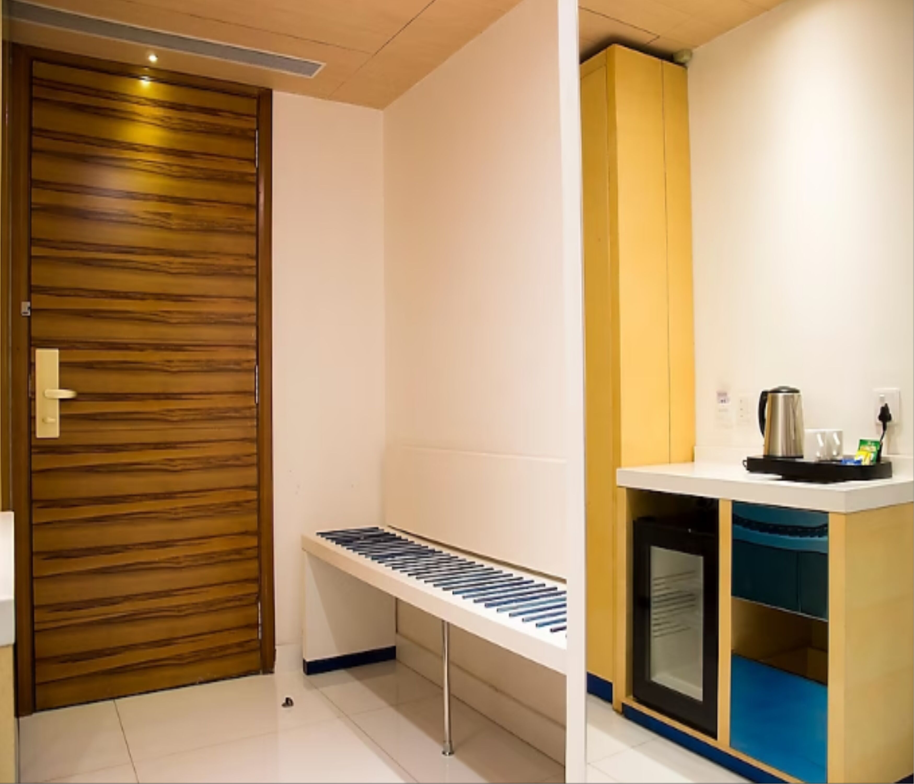 A modern kitchen with a wooden door, a built-in bench, and a microwave.