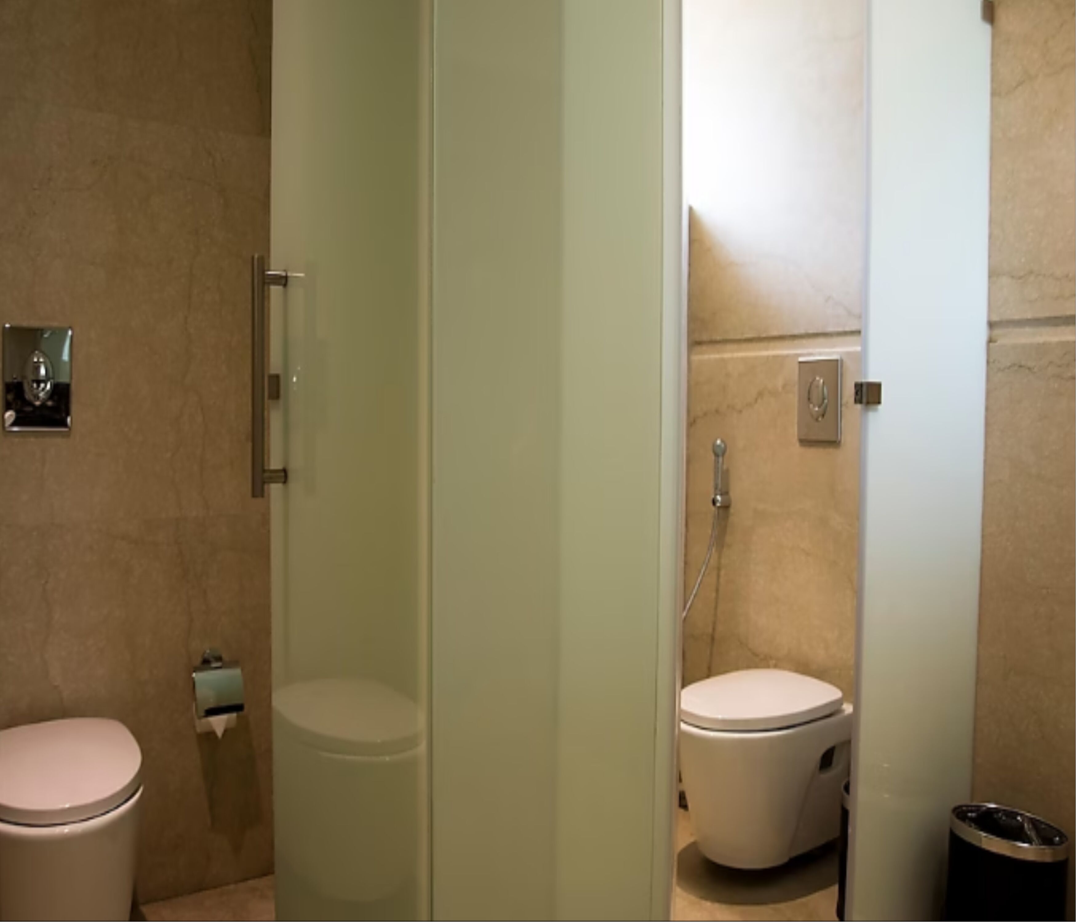 A bathroom with a toilet, a bidet, and a shower stall.