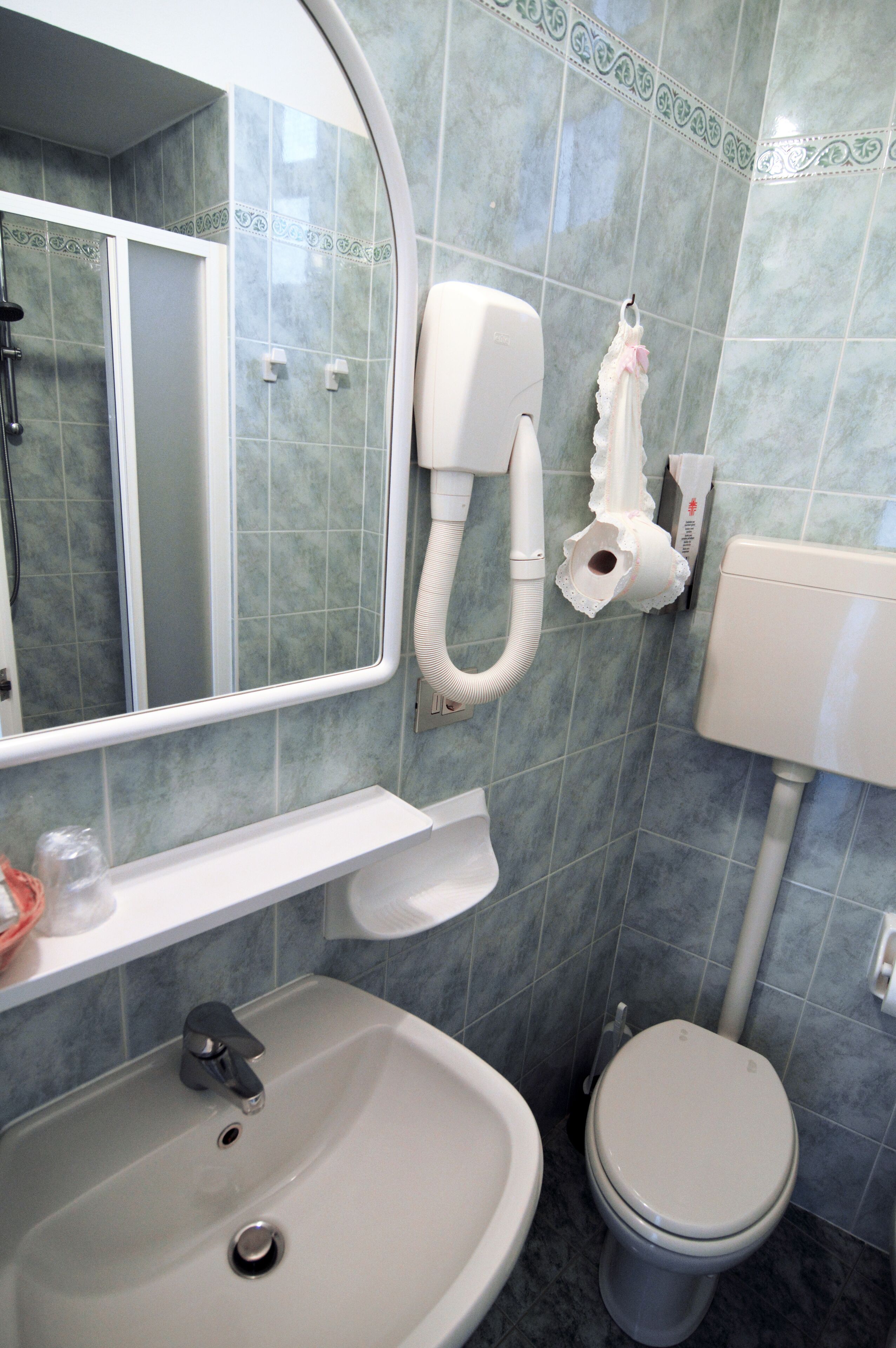 A bathroom with a sink, toilet, and a mirror.