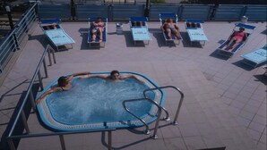 A swimming pool area with a hot tub, lounge chairs, and a tiled deck. - Hotel Adele (Bellaria-Igea Marina)