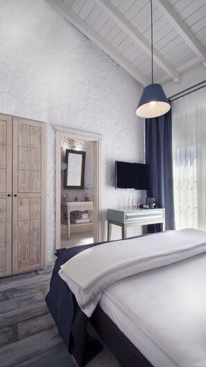Deluxe kamer | Luxe beddengoed, een minibar met enkele gratis items
