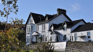 A large, white building with a prominent 'HOTEL' sign, featuring multiple windows and a traditional architectural style.