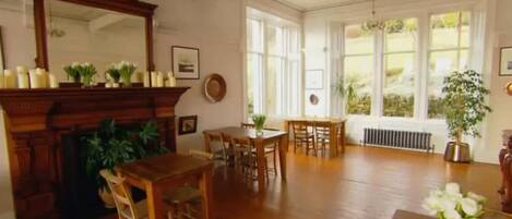 Una habitación amplia con chimenea, muebles de madera y ventanas grandes.