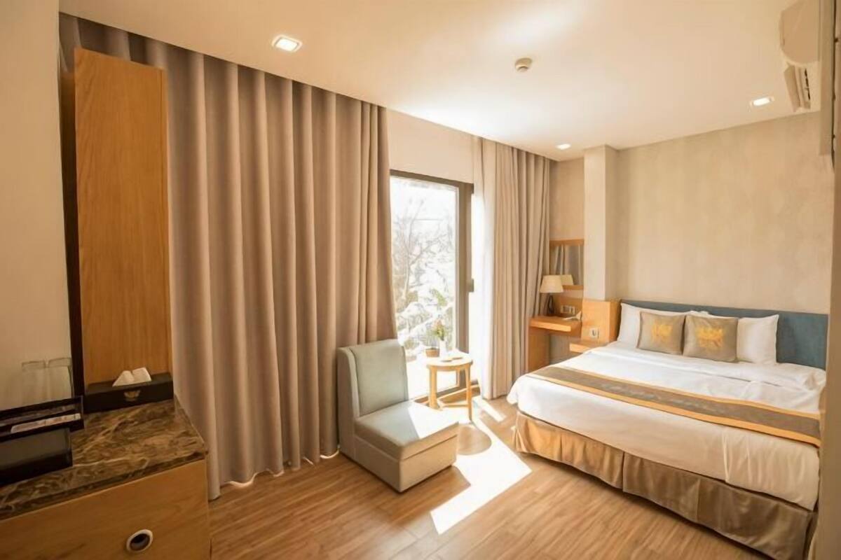Une chambre d’hôtel avec un lit, une chaise, un bureau et une armoire.