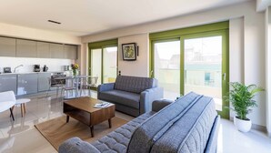 A modern living room with a sofa, coffee table, and dining area. - Athens Mosaico Suites and Apartments (Athens)
