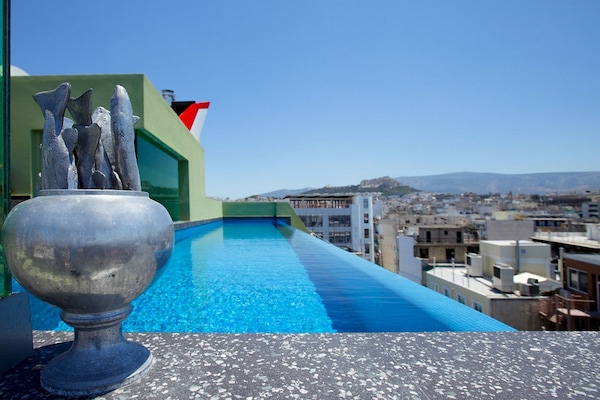 Una piscina al aire libre, sillones reclinables de piscina