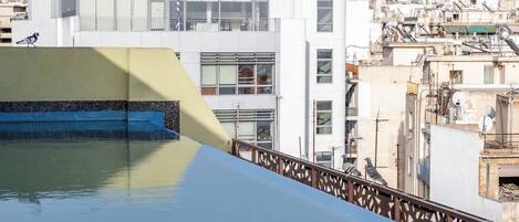 Une piscine sur le toit offrant une vue sur une zone urbaine densément peuplée.