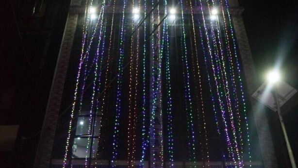 Exterior del Everest Holiday Inn con luces de colores y un cartel que indica que es un restaurante.