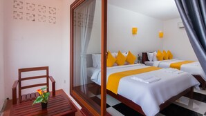 A hotel room with a large window, a wooden chair, a small table with a plant, two beds with yellow pillows, and a checkered floor. - Bou Savy Villa (Siem Reap)