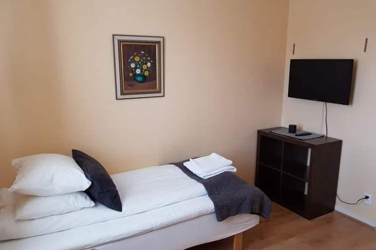 Cozy retreat with a bed, flat-screen TV, and artwork, perfect for a relaxing stay.