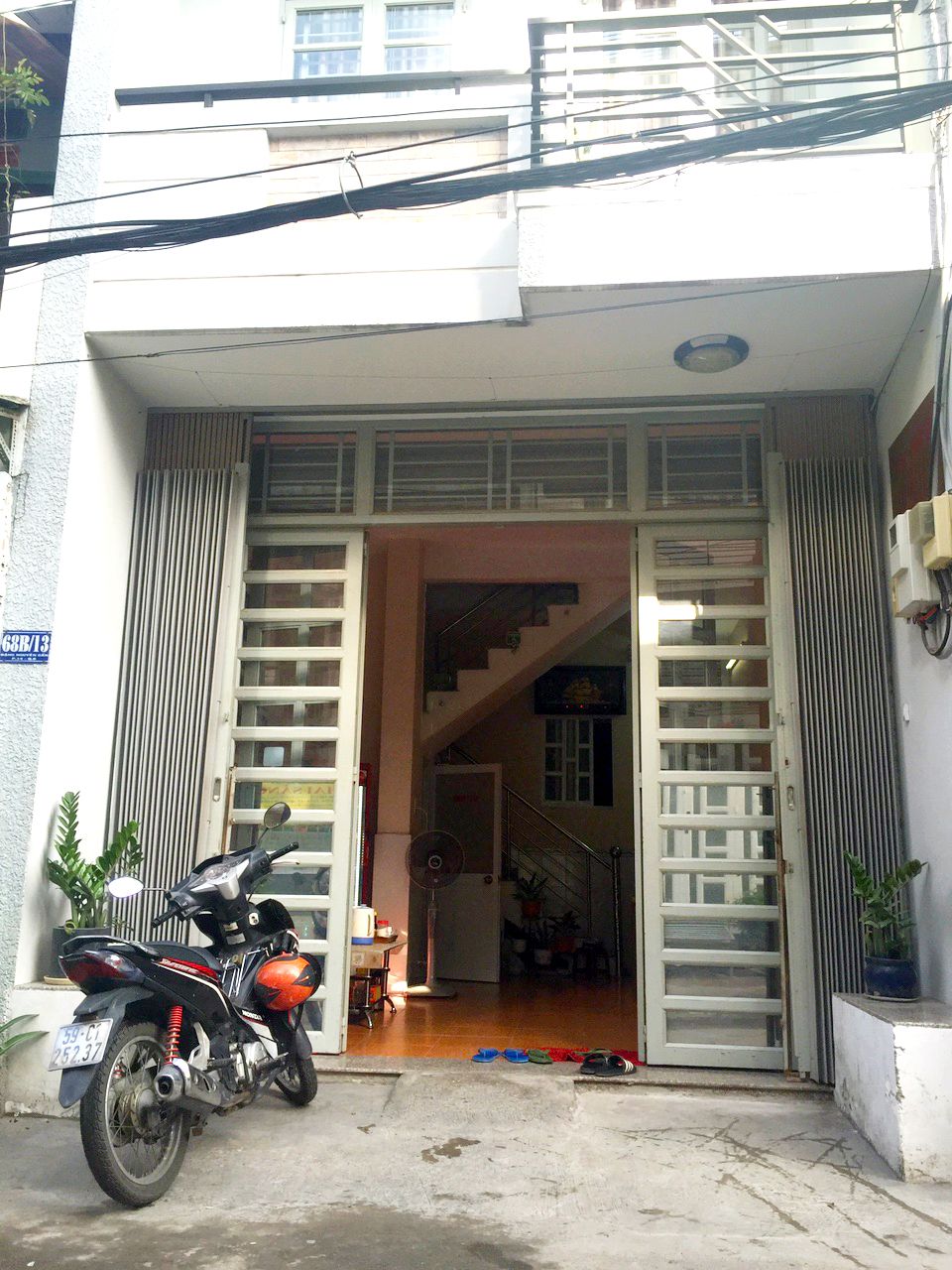 A motorcycle parked in front of a building with a staircase leading to an upper level.