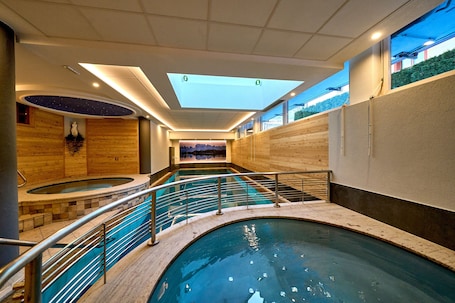 Una piscina techada, sillones reclinables de piscina. Hotel Cristina