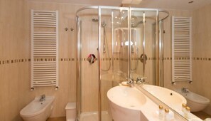 A modern bathroom with a glass-enclosed shower, two sinks, and a toilet. - Hotel Cristina (Pinzolo)